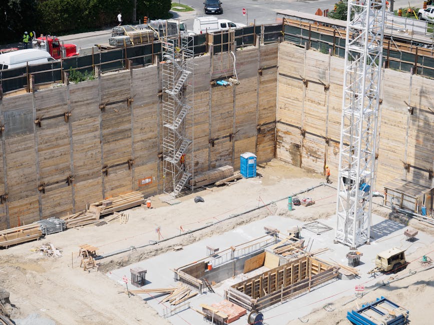 An aerial view of a construction site with workers and equipment under sunlight